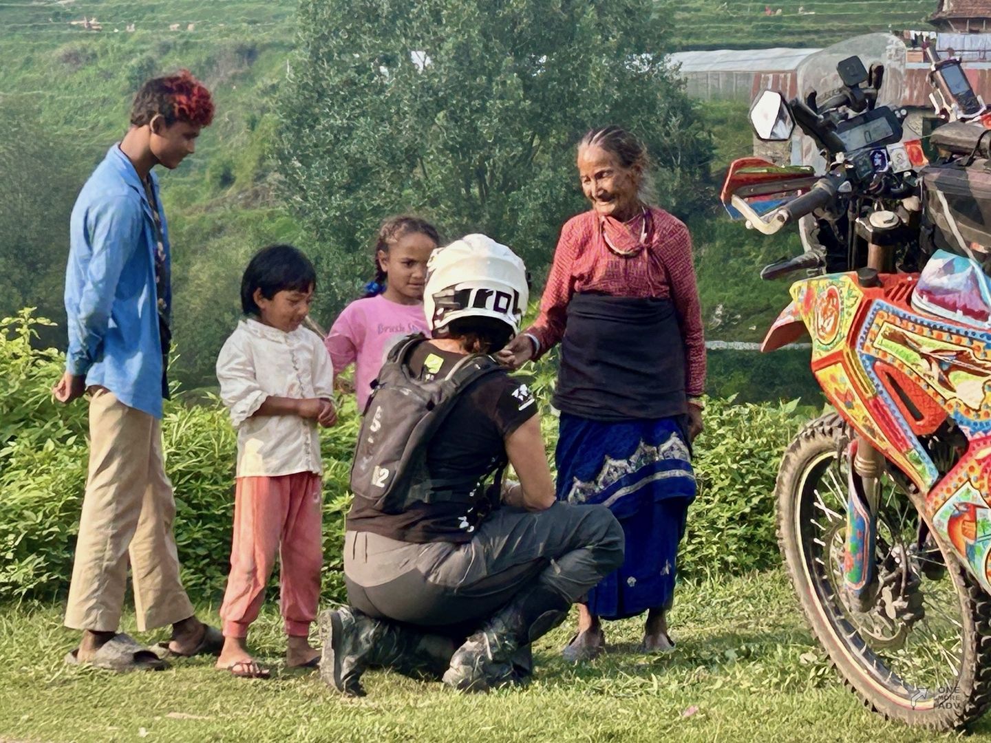 Motocyklistka w Nepalu wita się z mieszkańcami wioski